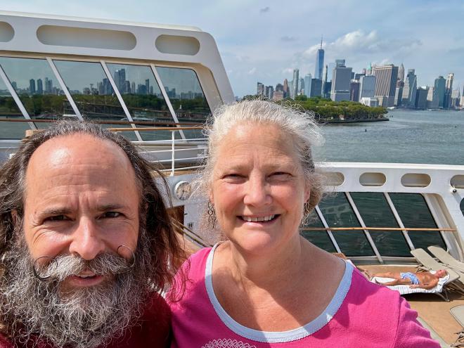 Karen and Greg on the Queen Mary 2, New York skyline in the background