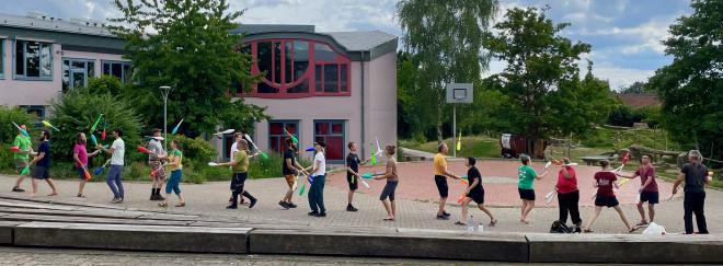 A long line of people juggling