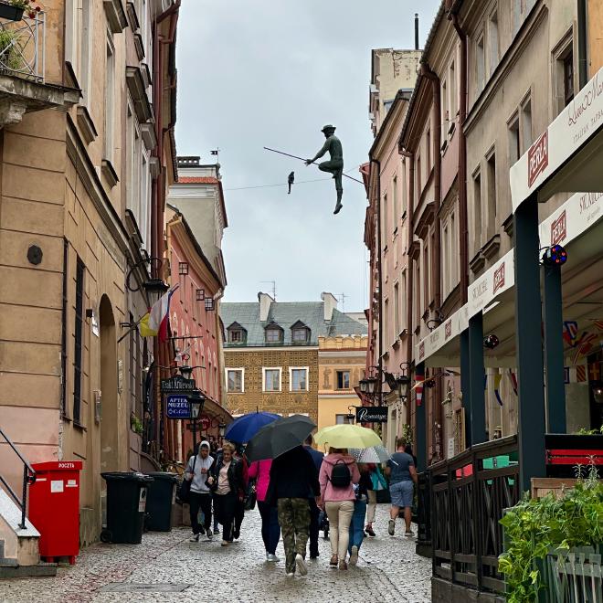 &ldquo;a statue of a highline walker, on a line above an old city street&rdquo;